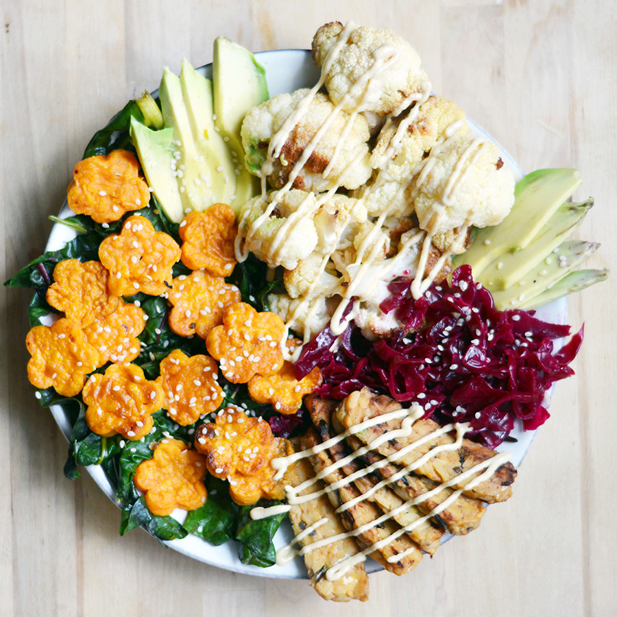 Macro bowl!! Roasted cauliflower, tempeh bacon, sauerkraut, avocado slices, baked sweet potato and lemon-tahini dressing over sauteed kale