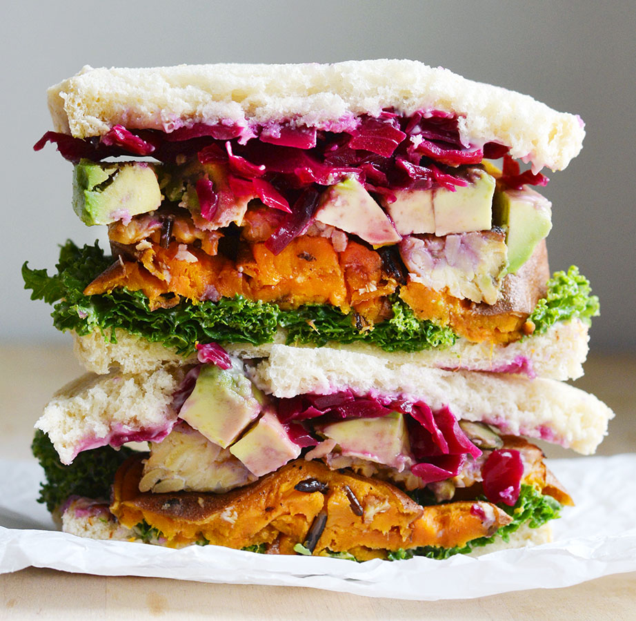 Sandwich! Kale salad, roasted sweet potato, tempeh bacon, avocado slices, sauerkraut and a smear of lemon-tahini dressing on spelt bread.